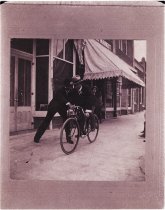 Thomas. Neville on bicycle & Ed Hotchkiss in front of Crews drug store